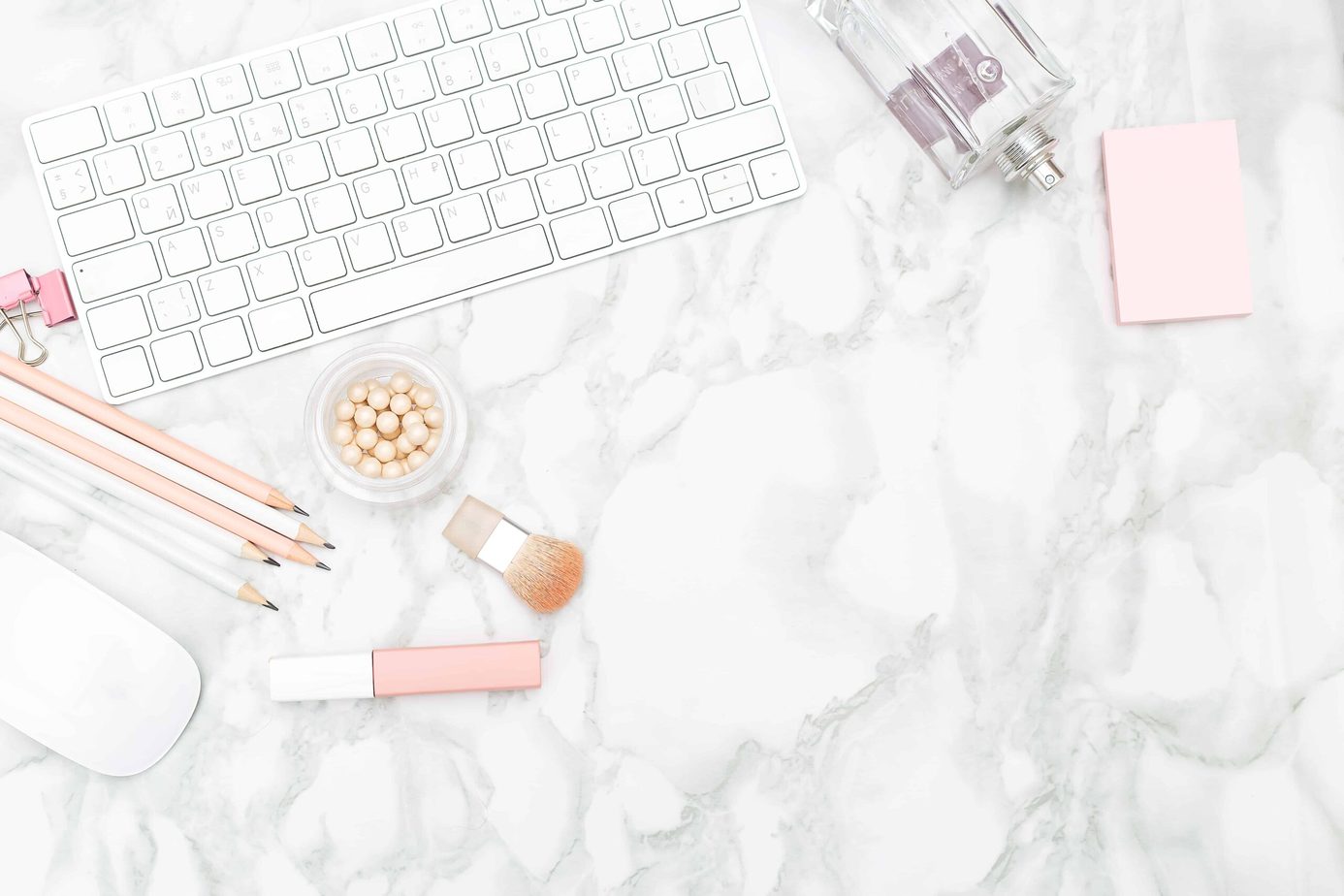Feminine desktop with stationery and perfume. Copy space