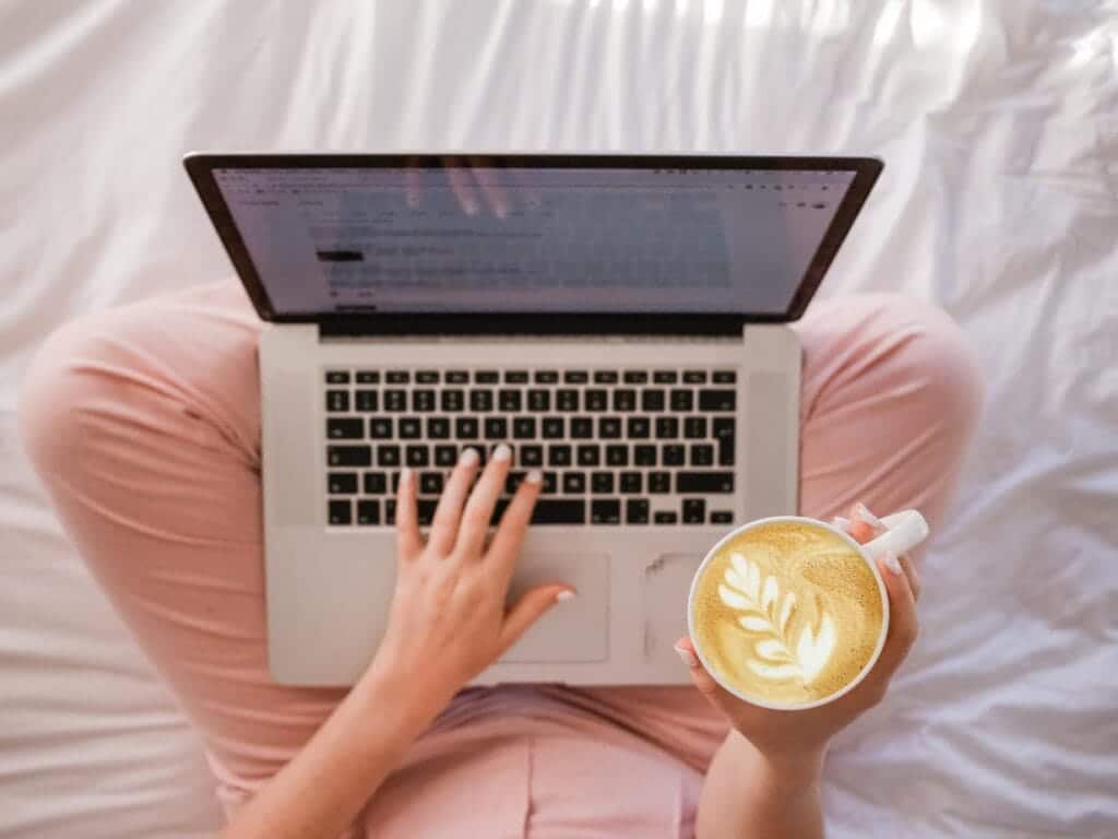 WordPress website maken - Zo start je een blog in 9 stappen. Vrouw met laptop op schoot en koffie in de hand. 
